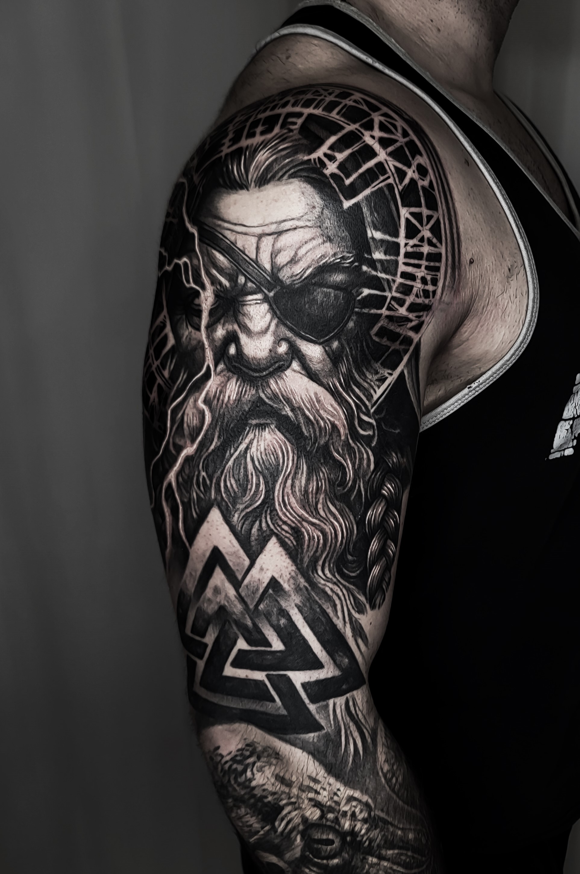 Black & grey tetovaža nordijskega bojevnika z brado in geometrijskimi simboli